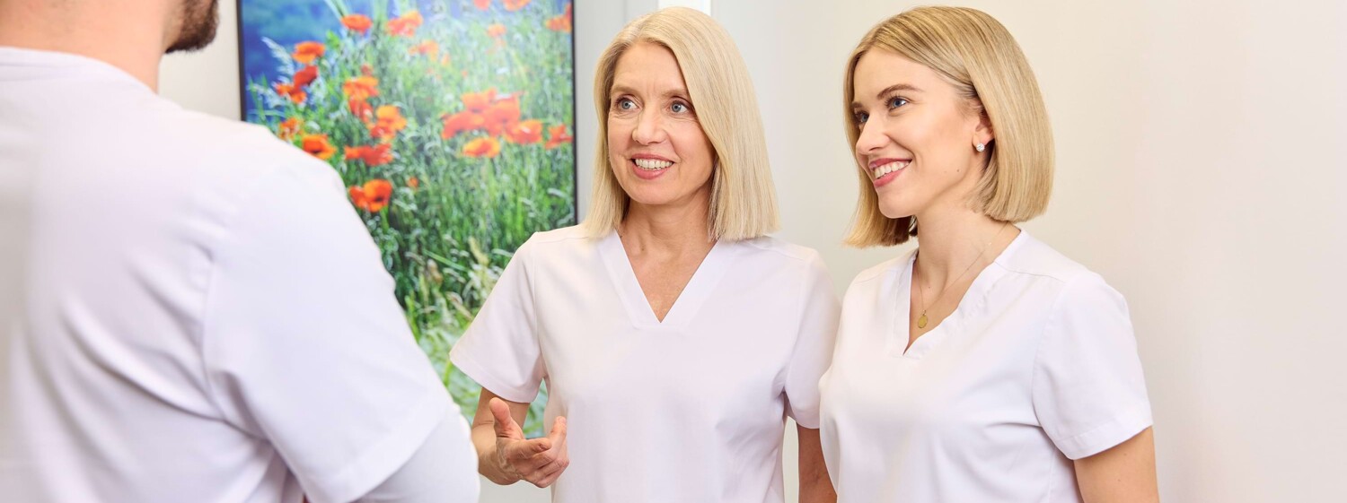 Julia Schneider und Silvia Hahn stehen im Flur mit Henrik Hahn im Gespräch