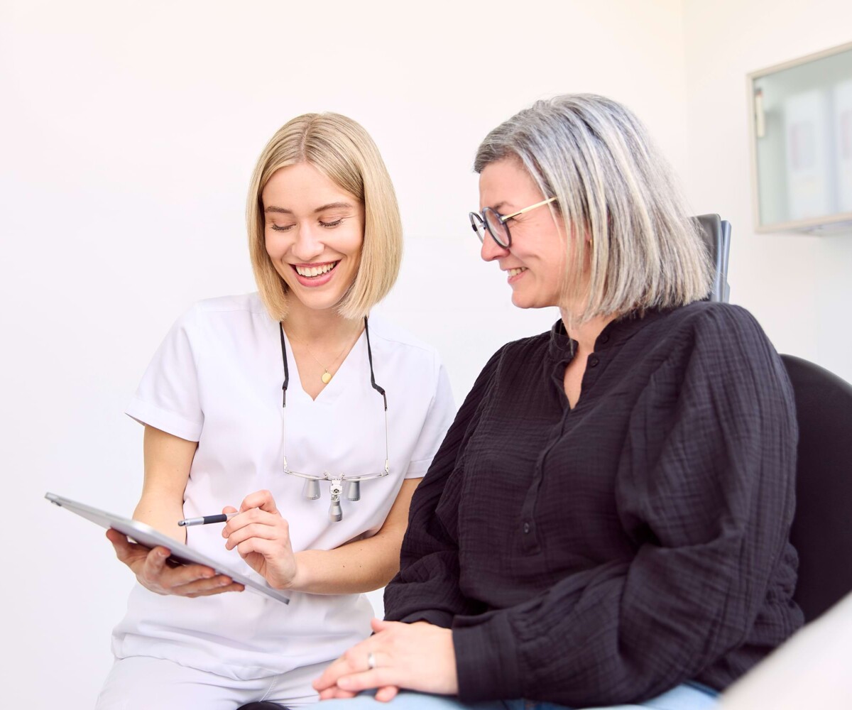 Julia Schneider im Gespräch mit einer Patientin im Behandlungsstuhl