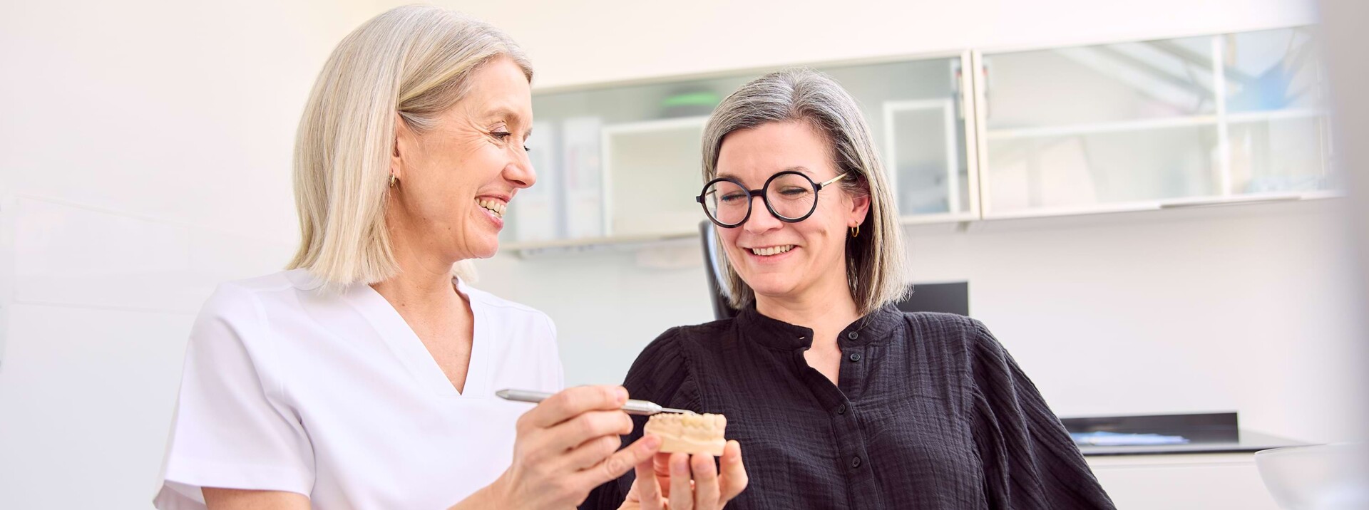 Dr. Hahn erklärt einer Patientin etwas am Behandlungsstuhl